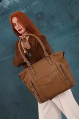 Cartera bandolera de símil cuero color marrón claro, con doble asa rígida y correa regulable. Presenta dos bolsillos frontales con cierre vertical y un bolsillo frontal con solapa y botón. Cuenta con dos divisiones internas.