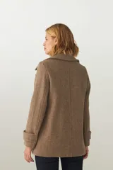 Chaquetón marrón de lana con cuello, abrochadura simple con botón en el cuello, bolsillos ojal y detalle de martingala en mangas.