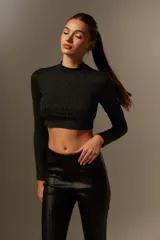 Top negro cropped de poliéster con cuello alto y mangas largas.