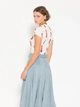 Remera de punto color crudo con estampado de ajíes rojos, cuello redondo y mangas cortas. Calce al cuerpo.