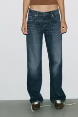 Pantalón de jean celeste claro, de tiro bajo, corte wide leg y largo hasta el tobillo. Tiene cinco bolsillos, cierre frontal con cremallera y botón metálico.