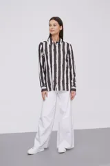 Camisa de manga larga con estampado a rayas verticales en tonos negro, blanco y verde claro.
