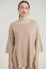 Conjunto de sweater y pantalón color beige con brillo metalizado. El sweater es holgado, de mangas 3/4 y cuello redondo. El pantalón es de corte palazzo.