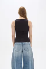 Musculosa negra ajustada al cuerpo, sin mangas y con cuello recto.