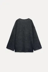 Top de punto color gris oscuro con escote redondo y mangas largas acampanadas.