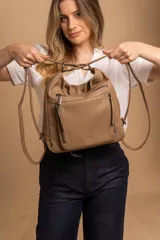 Cartera mochila color marrón de símil cuero suave con múltiples bolsillos con cierre, división al medio y correa ajustable de doble manija para llevar al hombro y como mochila.