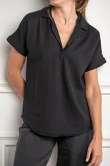 Blusa negra de lino y algodón con cuello camisero y mangas cortas con dobladillo.