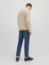 Sweater de punto color beige con cuello alto, cierre parcial con tres botones de madera y diseño con patrón de rombos y trenzas.