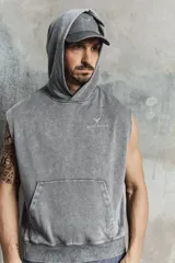 Buzo deportivo sin mangas en color gris con efecto lavado. Modelo de corte holgado con capucha forrada cruzada, bolsillo canguro y diseño reflectante en pecho y espalda. Remate acanalado ancho en el bajo. Interior cepillado suave.