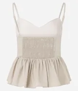 Blusa sin mangas color beige, con escote en V, breteles finos ajustables y peplum con volados en el bajo. Presenta lastex fruncido en la espalda.