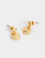 Aros colgantes cortos con dos dijes de corazones bañados en oro y cierre tope a presión.