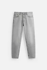 Pantalón de jean gris de corte slim fit tapered, con cinco bolsillos, efecto lavado y cierre frontal con cremallera y botón.