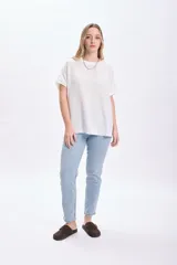 Camiseta blanca de manga corta con dobladillo en las mangas y cuello redondo.