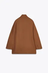 Blazer color marrón de cuello mao confeccionada en hilatura con mezcla de lino. Manga larga acabada en abertura y botones. Bolsillos con solapa en delantero.