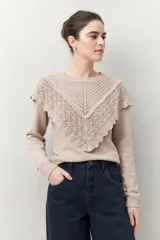Sweater color crema de punto liso con detalle de crochet en el escote y en forma de pico sobre el pecho.