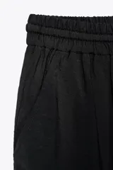 Pantalón jogger marrón de tiro alto con cintura elástica ajustable con cordones, bolsillos delanteros y puños elásticos en los tobillos.