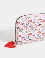 Billetera pequeña de cuerina color blanco con estampado de lazos rosas y corazones. Tiene cierre circundante y tirador de goma.