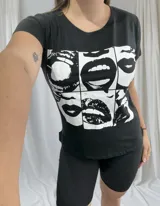 Remera negra de algodón con cuello redondo y estampado frontal de labios en blanco y negro.