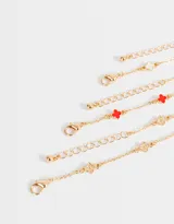 Set de tres pulseras doradas con dijes de flores de metal y resina.