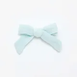 Pack de dos pinzas para el pelo con forma de moño, una celeste lisa y otra color crema con estampado de flores rosas.