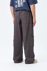 Pantalón cargo color beige, de corte recto y holgado, con cintura elástica y bolsillos laterales con solapa.