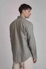 Camisa blanca de lino con cuello abotonado, manga larga con puños abotonados y corte clásico.