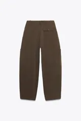Pantalón cargo negro de corte amplio con cintura ajustable con cordón, bolsillos laterales y bolsillos tipo parche en las piernas.