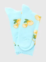 Calcetín largo medio de mujer, color celeste claro, con estampado de rodajas de limón y hojas verdes. El puño superior tiene un borde festoneado.