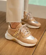 Zapatillas deportivas color beige con detalles dorados, cordones al tono y suela blanca.