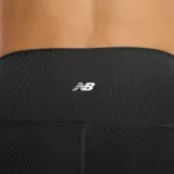 Calza corta deportiva de tiro alto, color negro, con textura acanalada y líneas de contorno sutiles.
