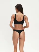 Colaless blanca de tejido liso, sin costuras (seamless), con corte bajo y tiro bajo.