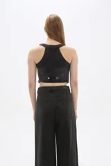 Chaleco de jean celeste sin mangas, con cuello en V, cierre frontal con botones y dos bolsillos con solapa en el pecho.