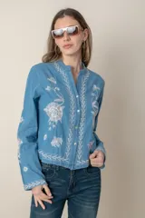 Camisa de jean celeste con bordados de flores blancas en hilo de seda, cuello mao y cierre frontal con botones.