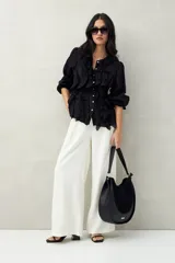 Camisa negra de tencel liviana con volados románticos y manga corta.