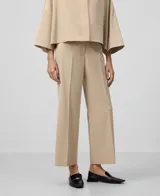 Pantalón tobillero color beige, de corte recto, con trabillas, bolsillos laterales y bolsillos de vivo en la espalda.