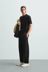 Pantalón verde militar de corte carrot fit, confeccionado en tejido de algodón. Cuenta con cintura elástica ajustable con cordón, bolsillos frontales y un bolsillo trasero de plastrón.