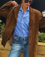 Blazer de gamuza color camel, con solapas de muesca, cierre con dos botones, bolsillos laterales con solapa y forro interior.