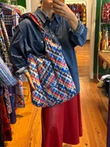Bolso tipo tote bag con estampado a cuadros en tonos azul, rojo y blanco.