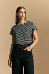 Remera de manga corta con cuello redondo, confeccionada en tejido acanalado a rayas horizontales blancas y negras.