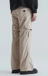 Pantalón cargo beige de corderoy con calce regular y seis bolsillos.
