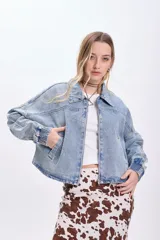 Campera de jean celeste, corte cropped, con cuello clásico, cierre frontal con cremallera, mangas largas con puños elásticos y bolsillos laterales.