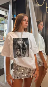 Remera blanca de algodón, corte oversize, con estampa fotográfica en blanco y negro de una mujer con cabello largo y accesorios.