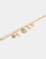 Collar corto dorado de doble cadena, una de eslabones y otra de perlas sintéticas. Incluye dijes de cruz, bota cowboy, moneda antigua y otros.