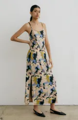 Vestido midi de tirantes finos con estampado floral en tonos azul, negro y naranja. Tiene escote redondo y tajo lateral.