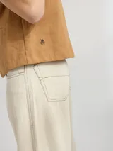 Chaleco color caramelo confeccionado en lino, de corte relajado y con bordado de una mariquita en el frente.