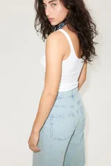 Pantalón jean de tiro bajo en denim bouclé celeste, de algodón rígido, con cinco bolsillos, cierre con botón y corte holgado con piernas amplias.