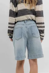 Bermuda de jean celeste con corte relajado, ruedo desflecado y diseño clásico de cinco bolsillos.