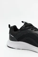 Zapatillas deportivas negras de tela transpirable con cordones a tono y suela blanca de 3cm de alto.