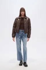 Campera estilo bomber de eco-cuero color marrón oscuro, con cuello camisero, cierre frontal y puños y cintura ajustados.