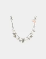 Llavero metálico plateado con cadenas y dijes de moños, mariposas de metal, corazones traslúcidos y flor rosa.